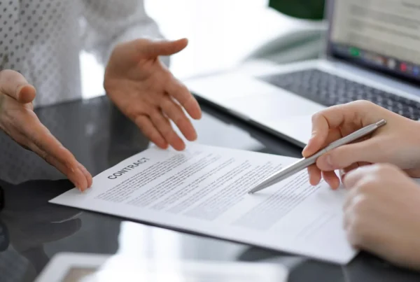Ejecutivos revisando y firmando contrato comercial en oficina, representando confianza empresarial, reducción de DSO y gestión de riesgo B2B en México.