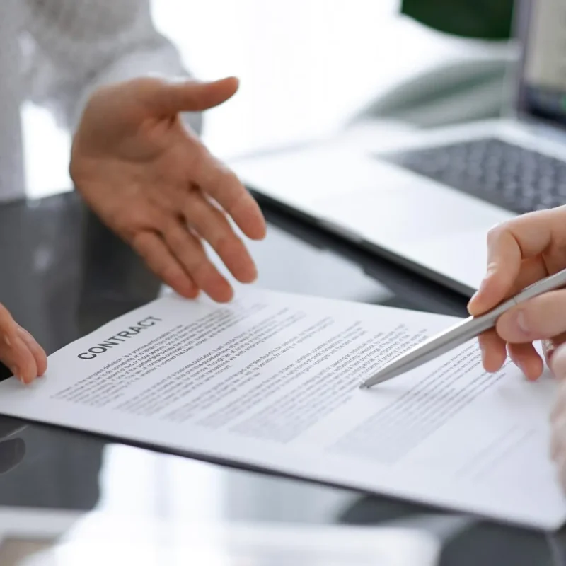 Ejecutivos revisando y firmando contrato comercial en oficina, representando confianza empresarial, reducción de DSO y gestión de riesgo B2B en México.
