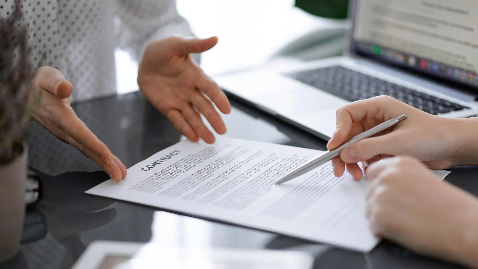 Ejecutivos revisando y firmando contrato comercial en oficina, representando confianza empresarial, reducción de DSO y gestión de riesgo B2B en México.
